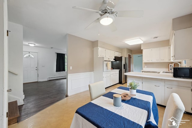 dining area with a baseboard radiator, a ceiling fan, and wainscoting