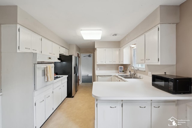 kitchen featuring white appliances, a sink, a peninsula, light countertops, and white cabinets