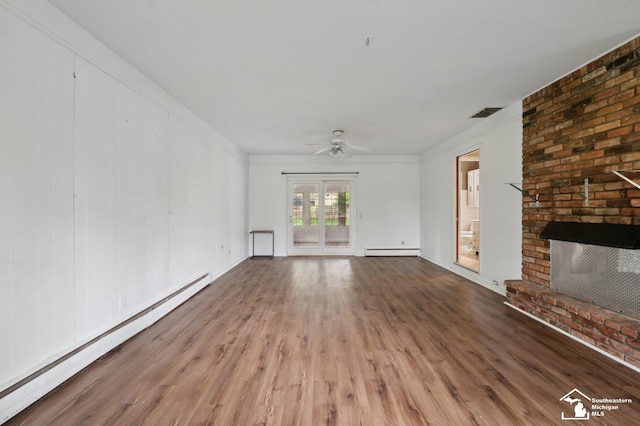 unfurnished living room with baseboard heating, a brick fireplace, wood finished floors, ceiling fan, and crown molding