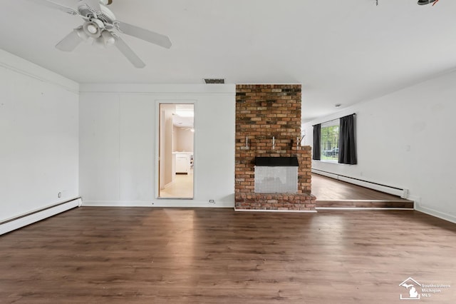 unfurnished living room with baseboard heating, wood finished floors, a brick fireplace, baseboards, and a ceiling fan