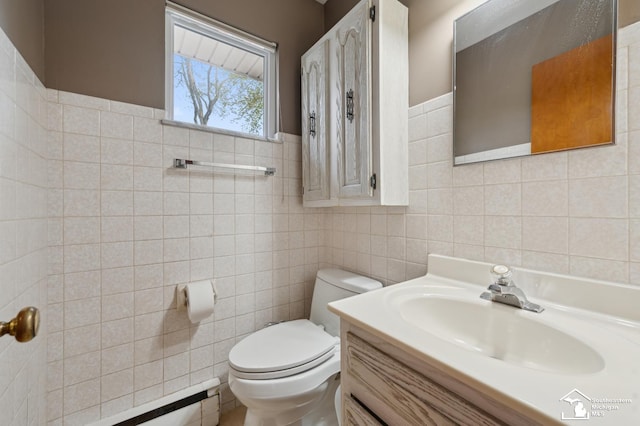 bathroom featuring tile walls, toilet, vanity, and a baseboard radiator