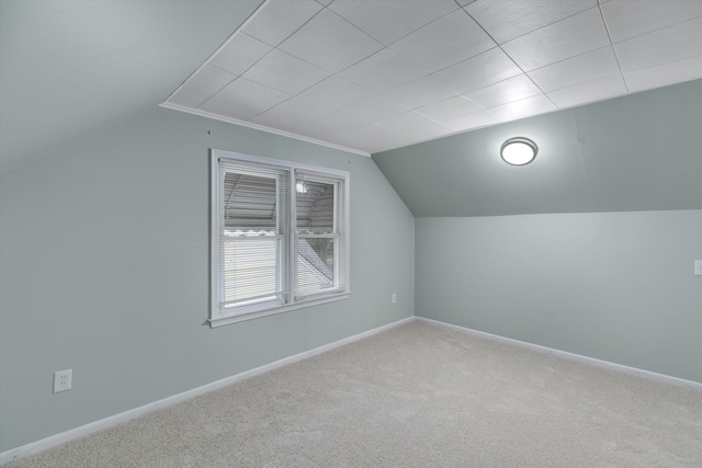 additional living space with carpet flooring, vaulted ceiling, and baseboards