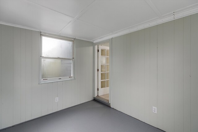 unfurnished room with concrete floors and wood walls