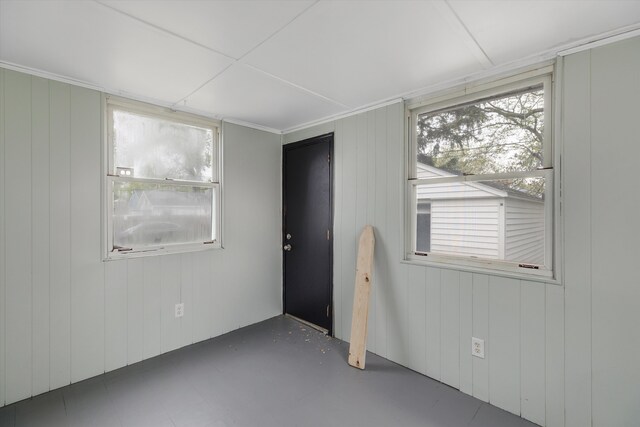 unfurnished room featuring wood walls