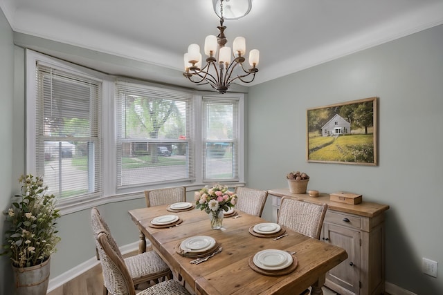 dining area with a chandelier, baseboards, and wood finished floors