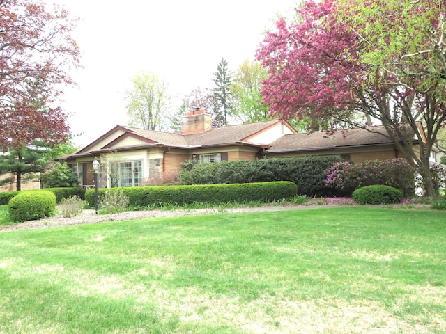 view of property exterior with a chimney and a lawn
