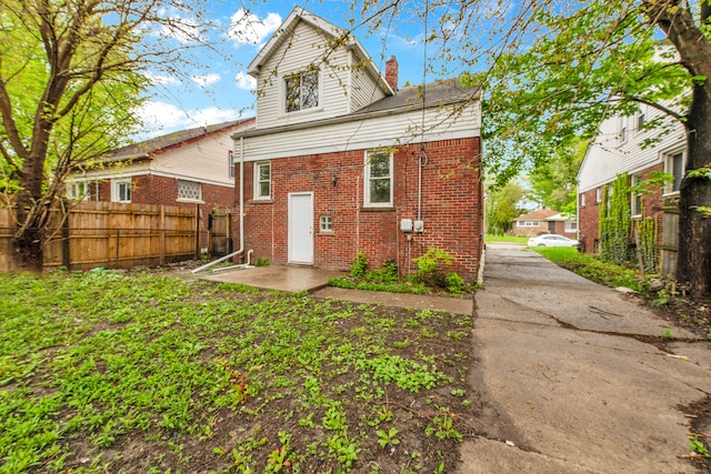 9171 Bishop St, Detroit, MI 48224 - back of house with brick siding, a chimney, fence, and a patio