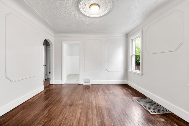 9171 Bishop St, Detroit, MI 48224 - unfurnished room featuring arched walkways, wood finished floors, baseboards, and a textured ceiling