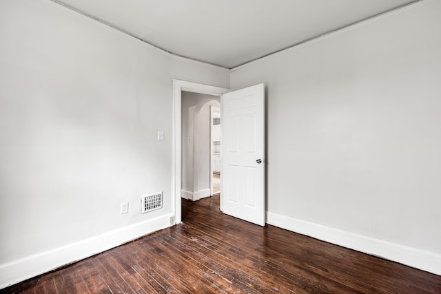 9171 Bishop St, Detroit, MI 48224 - empty room with baseboards, arched walkways, and dark wood-style flooring