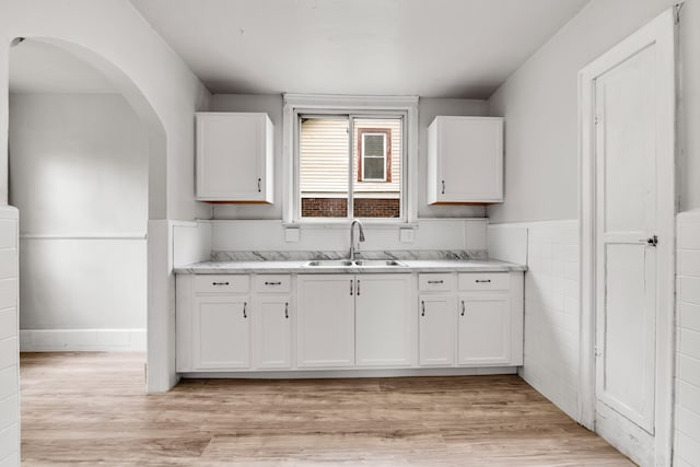9171 Bishop St, Detroit, MI 48224 - kitchen featuring a sink, white cabinets, light countertops, light wood-type flooring, and wainscoting