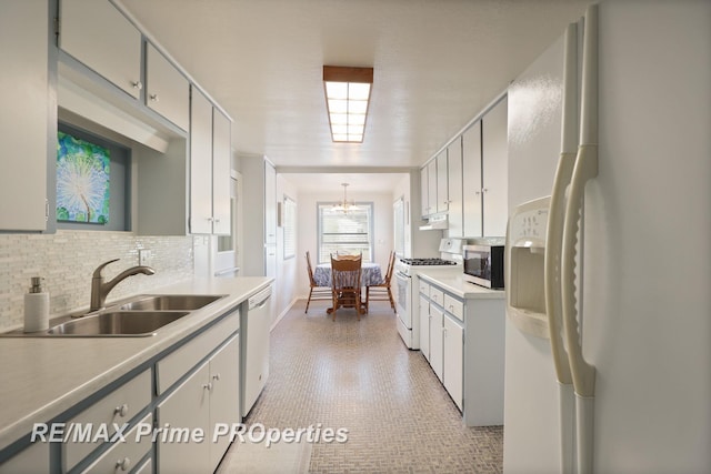 kitchen with white appliances, a sink, decorative backsplash, and light countertops