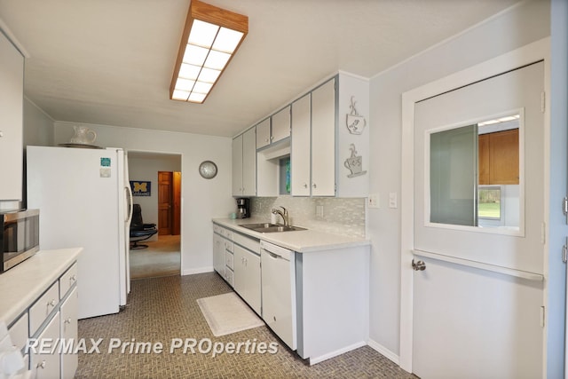 kitchen with white appliances, a sink, light countertops, backsplash, and white cabinetry