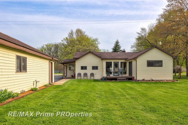 rear view of property with a deck and a yard