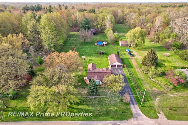 aerial view of property and surrounding area featuring a heavily wooded area