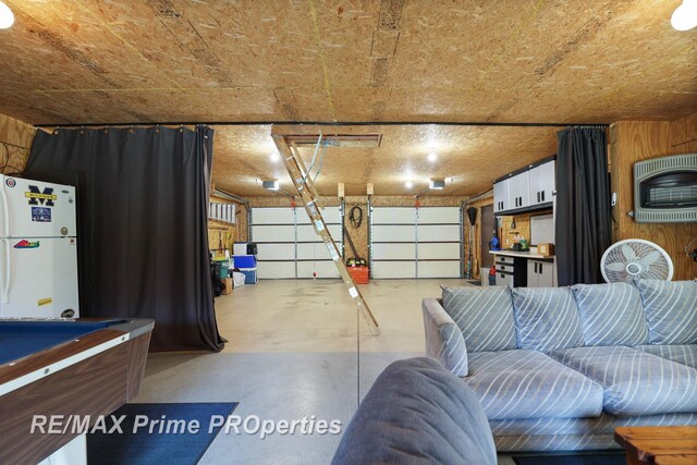 garage with freestanding refrigerator and heating unit