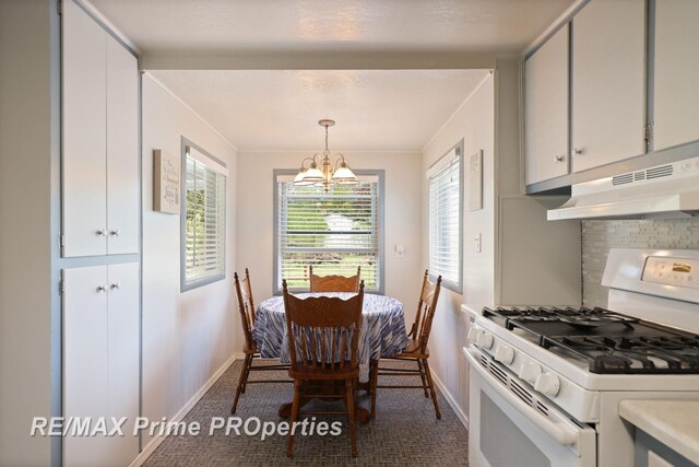 dining area featuring baseboards, a chandelier, ornamental molding, and carpet
