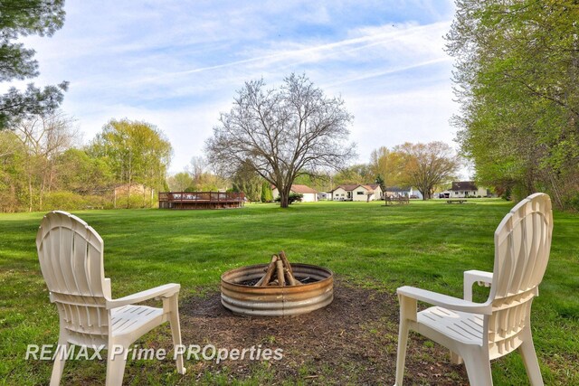 view of grassy yard with a fire pit