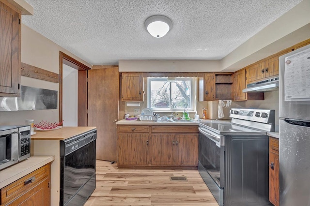 3127 Keewahdin Rd, Fort Gratiot, MI 48059 - kitchen with appliances with stainless steel finishes, under cabinet range hood, brown cabinetry, light wood-style floors, and light countertops