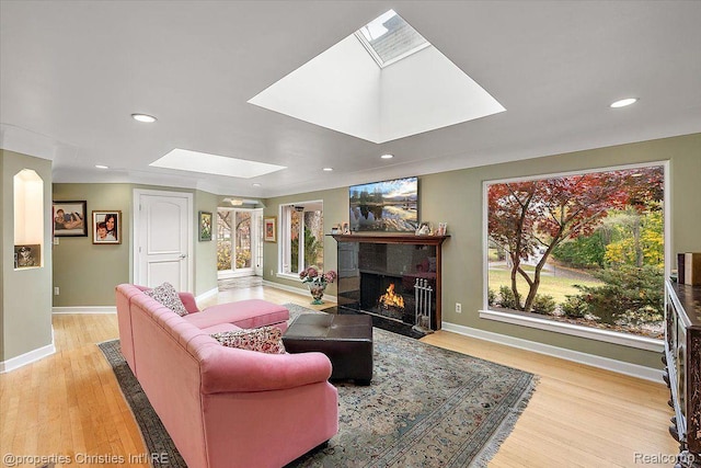 26335 Woodlore Rd, Franklin, MI 48025 - living room with a skylight, light wood-style floors, a fireplace with flush hearth, and recessed lighting
