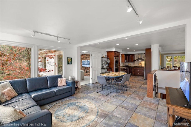 26335 Woodlore Rd, Franklin, MI 48025 - living room featuring rail lighting, recessed lighting, decorative columns, and light stone finish floors