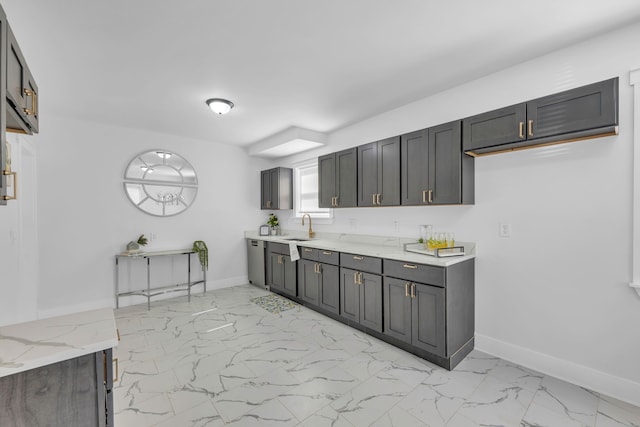 371 W Saratoga, Ferndale, MI 48220 - kitchen with stainless steel dishwasher, a sink, light marble finish flooring, light stone countertops, and baseboards