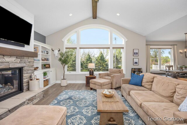2044 Canopy Dr SW, Byron Center, MI 49315 - living room featuring healthy amount of natural light, wood finished floors, a fireplace, and a chandelier