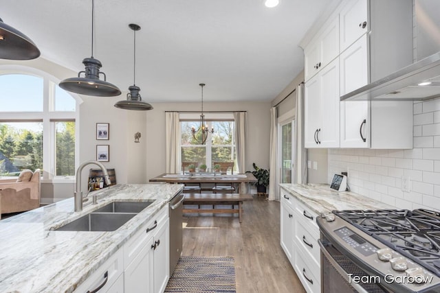 2044 Canopy Dr SW, Byron Center, MI 49315 - kitchen with a sink, stainless steel appliances, wall chimney range hood, white cabinets, and recessed lighting