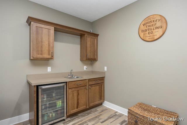 2044 Canopy Dr SW, Byron Center, MI 49315 - bar with beverage cooler, a sink, light wood-type flooring, and baseboards