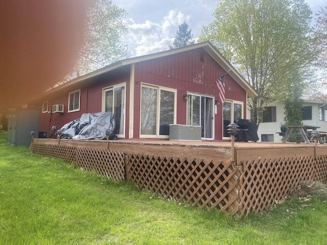 12765 NE Gregware Dr NE, Sand Lake, MI 49343 - rear view of house featuring a wooden deck, a lawn, and a wall mounted AC