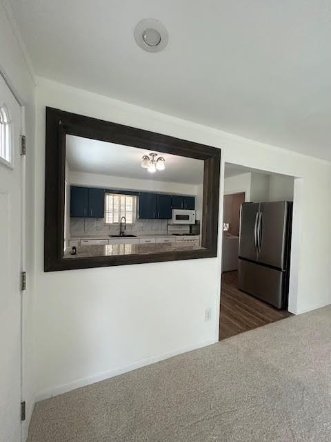 29424 Shirley Ave, Madison Heights, MI 48071 - kitchen with freestanding refrigerator, dark countertops, a sink, white microwave, and dark colored carpet
