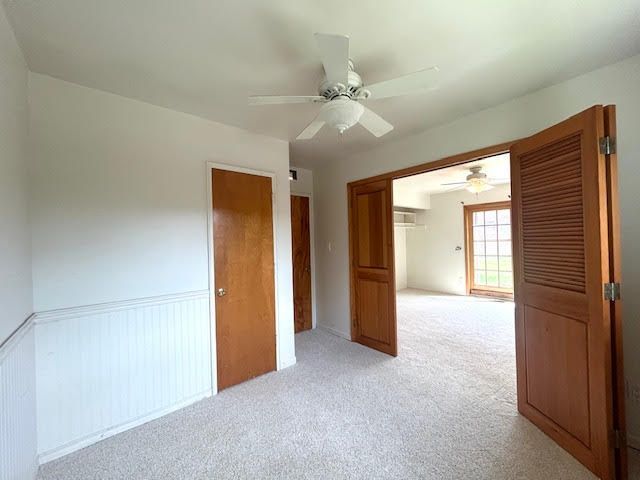 29424 Shirley Ave, Madison Heights, MI 48071 - empty room featuring light colored carpet, ceiling fan, and a wainscoted wall