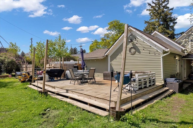 back of property featuring a wooden deck and outdoor dining space