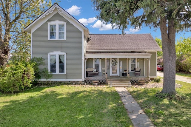 view of front of property featuring a front lawn, a porch, and roof with shingles