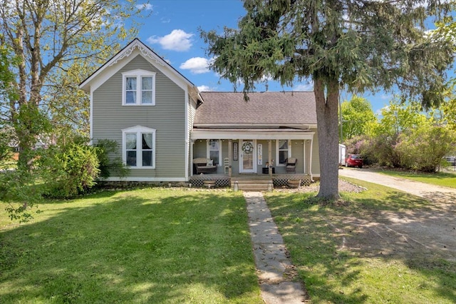 traditional-style home with a porch, a front lawn, and roof with shingles