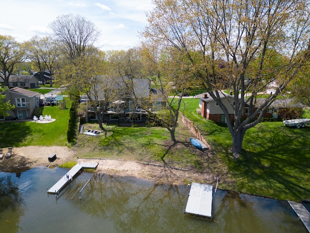 dock area with a water view, a residential view, and a lawn
