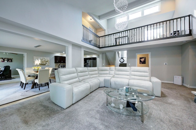 living area with a chandelier, a high ceiling, carpet, and baseboards