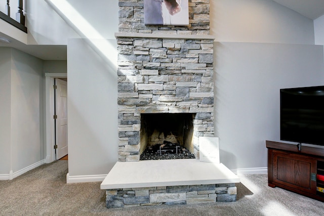 detailed view of carpet floors, baseboards, and a fireplace