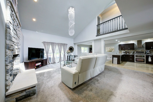 living room featuring high vaulted ceiling, light colored carpet, and recessed lighting
