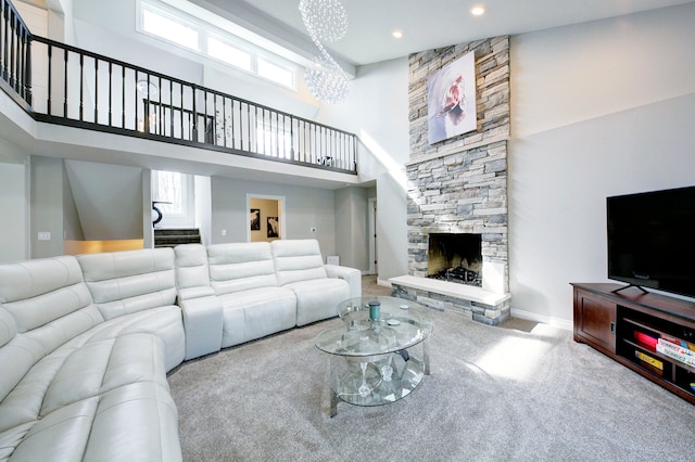 living area with carpet, a chandelier, a high ceiling, a stone fireplace, and stairway