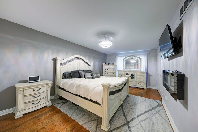 bedroom with baseboards and dark wood-type flooring