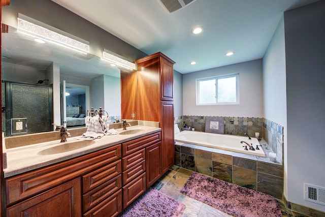 bathroom featuring a bath, double vanity, recessed lighting, and an enclosed shower