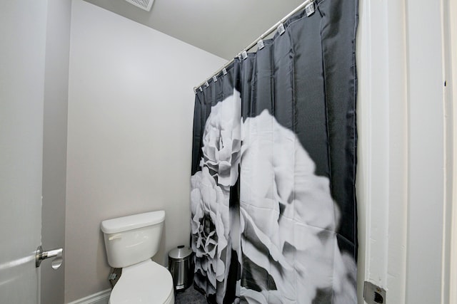 full bath with toilet, baseboards, and a shower with shower curtain