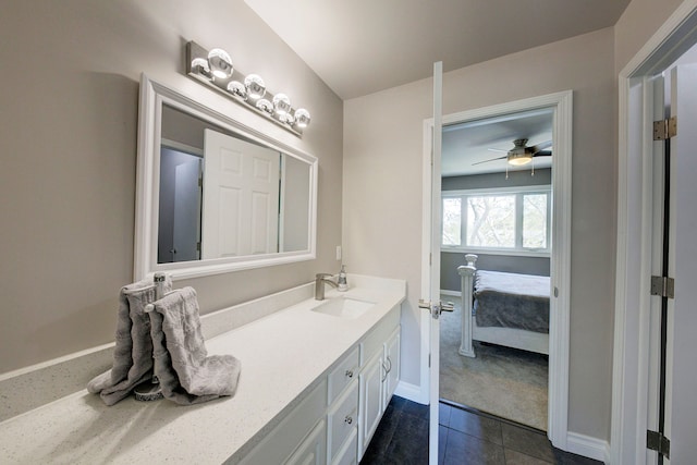 ensuite bathroom featuring vanity, tile patterned floors, baseboards, and a ceiling fan