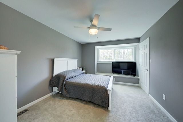 bedroom with light colored carpet, ceiling fan, and baseboards