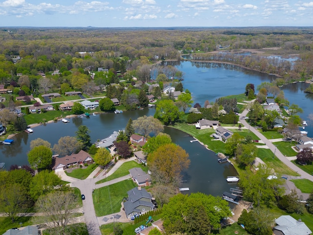 aerial overview of property's location featuring a large body of water, a heavily wooded area, and nearby suburban area