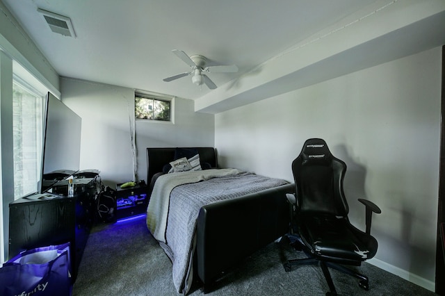 carpeted bedroom featuring multiple windows and a ceiling fan