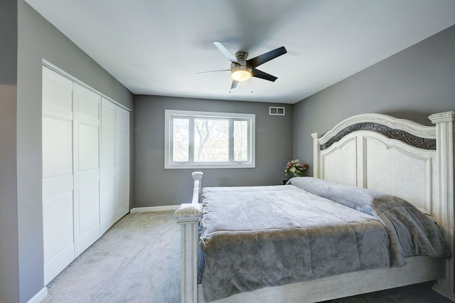 bedroom featuring light carpet, a closet, ceiling fan, and baseboards