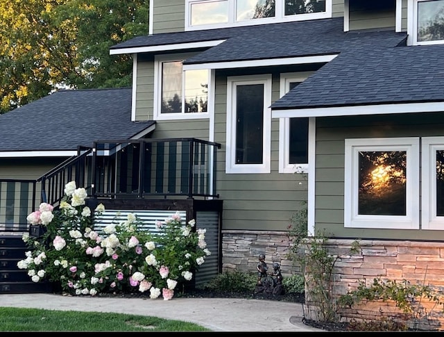 view of exterior entry featuring roof with shingles