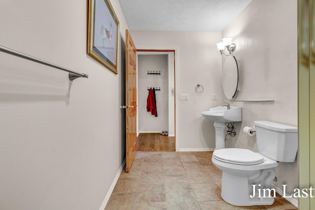 bathroom featuring toilet and baseboards