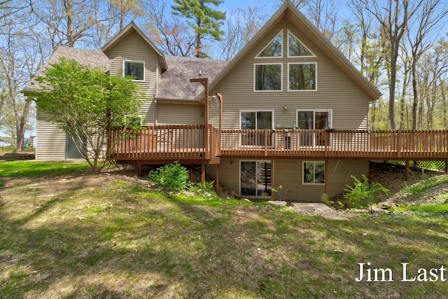 back of house with a wooden deck and roof with shingles